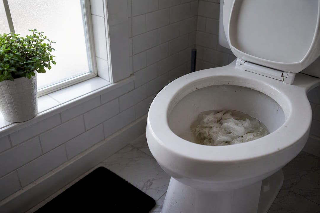 Toilet bowl clogged with paper towels and wipes