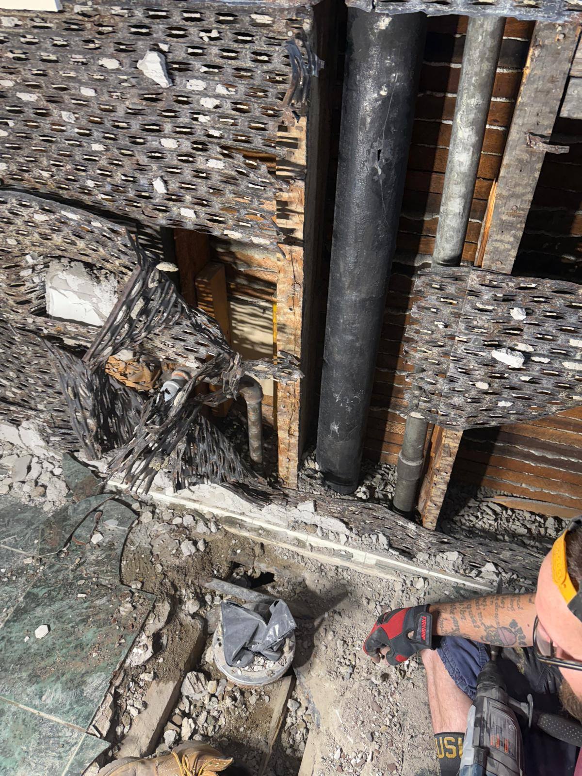 Exposed drain pipe and wall opening during a residential plumbing repair