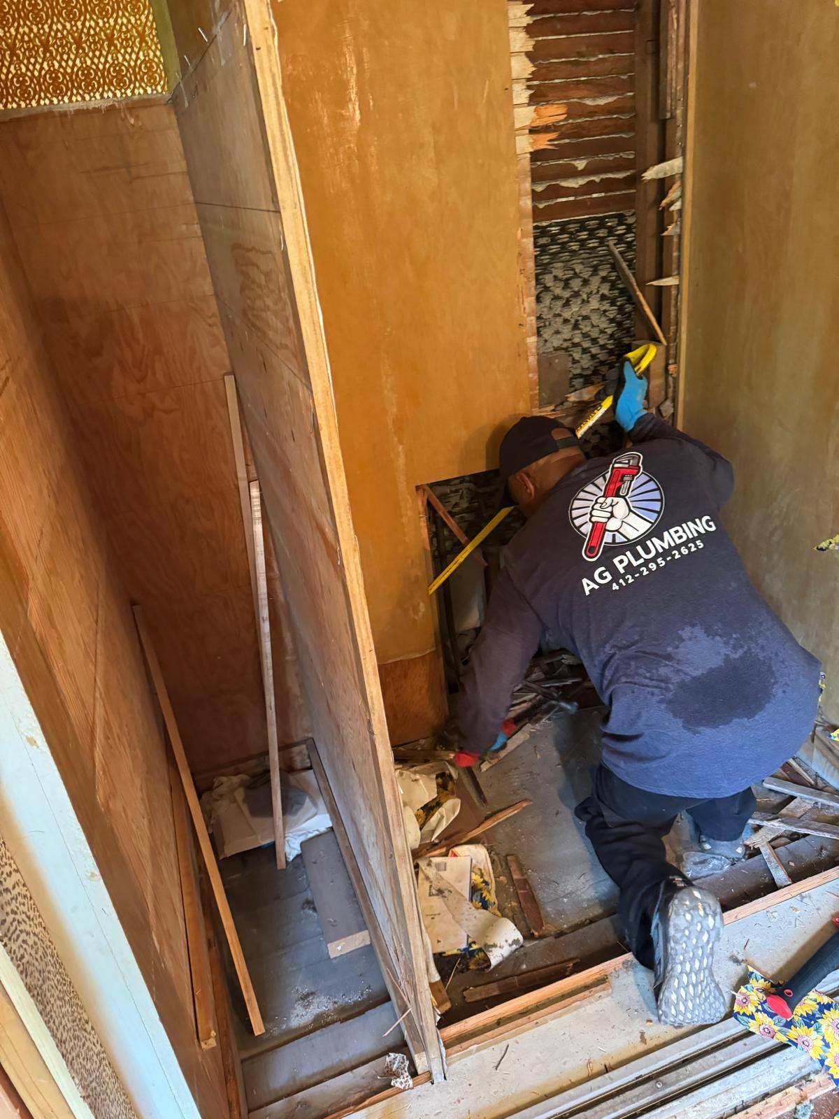 AG Plumbing technician working on interior pipe access