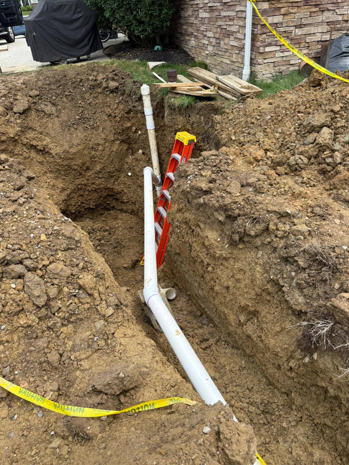 Underground PVC piping in a trench beside a residential property